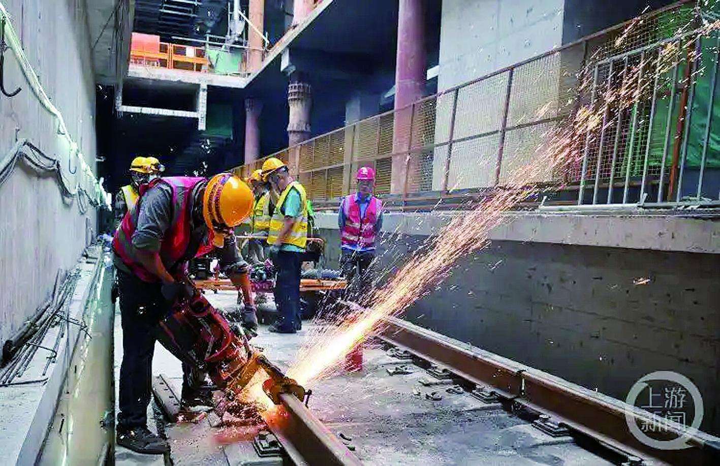 施工现场，工人对钢轨头进行无缝焊接。